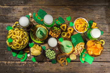 St Patrick`s holiday party invitation, bar menu background. Irish St Patrick`s day beer, ale glasses, snacks, appetizer, green burger, wooden bar table with shamrock, clover, coins, leprechaun hat 