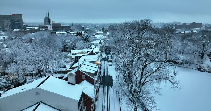 Lancaster Pennsylvania in fresh winter snow at dawn. Daybreak descending aerial in morning. USA establishing shot at Christmas.