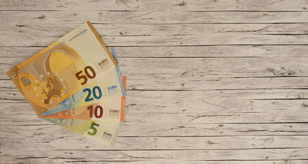 Verschiedene Eurobanknoten in fächerform liegend auf einem Holztisch