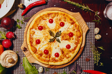 Hot pizza with cheese and tomatoes on a wooden tray 