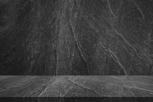 Empty black marble table top with black stone wall texture background
