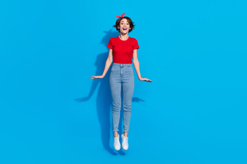 Full body photo of young cheerful lovely woman jumper fly dream travel isolated over blue color background