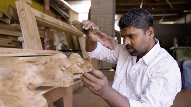 carpenter busy making wood design by shaping using carpentry tools at shop - concept of creativity, skilled labour and wood worker