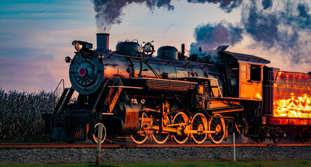 A View of an Antique Steam Passenger Train Approaching at Sunrise With a Full Head of Steam and...