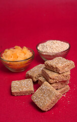 Indian makar sankranti festival food or sweets. Tilgul in a small bowl. Tilgul is made out of sesame seeds, peanuts, and jaggery. Til gud chikki or sesame candy. Copy Space.