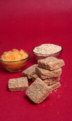 Indian makar sankranti festival food or sweets. Tilgul in a small bowl. Tilgul is made out of sesame seeds, peanuts, and jaggery. Til gud chikki or sesame candy. Copy Space.