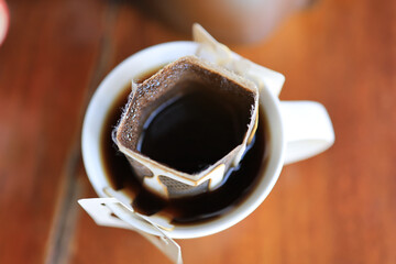 top view closeup sachet drip coffee ear in a white cup