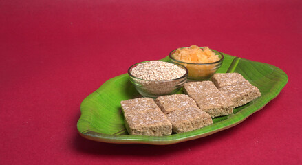 Indian makar sankranti festival food or sweets. Tilgul in a small bowl. Tilgul is made out of sesame seeds, peanuts, and jaggery. Til gud chikki or sesame candy. Copy Space.