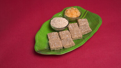 Indian makar sankranti festival food or sweets. Tilgul in a small bowl. Tilgul is made out of sesame seeds, peanuts, and jaggery. Til gud chikki or sesame candy. Copy Space.