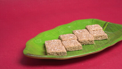 Indian makar sankranti festival food or sweets. Tilgul in a small bowl. Tilgul is made out of sesame seeds, peanuts, and jaggery. Til gud chikki or sesame candy. Copy Space.