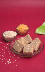 Indian makar sankranti festival food or sweets. Tilgul in a small bowl. Tilgul is made out of sesame seeds, peanuts, and jaggery. Til gud chikki or sesame candy. Copy Space.