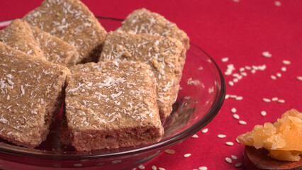 Indian makar sankranti festival food or sweets. Tilgul in a small bowl. Tilgul is made out of sesame seeds, peanuts, and jaggery. Til gud chikki or sesame candy. Copy Space.
