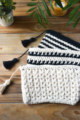 crocheted toiletry bag on wooden background with plants and candle