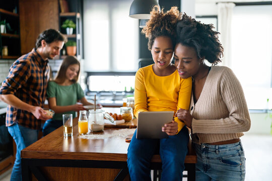 Happy multiethnic family having fun in the kitchen at home. People happiness technology concept.