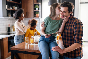 Happy multiethnic family having fun while cooking and using digital tablet at home