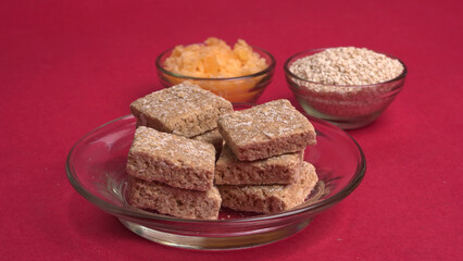 Indian makar sankranti festival food or sweets. Tilgul in a small bowl. Tilgul is made out of sesame seeds, peanuts, and jaggery. Til gud chikki or sesame candy. Copy Space.