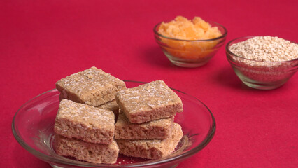 Indian makar sankranti festival food or sweets. Tilgul in a small bowl. Tilgul is made out of sesame seeds, peanuts, and jaggery. Til gud chikki or sesame candy. Copy Space.
