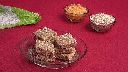 Indian makar sankranti festival food or sweets. Tilgul in a small bowl. Tilgul is made out of sesame seeds, peanuts, and jaggery. Til gud chikki or sesame candy. Copy Space.