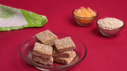 Indian makar sankranti festival food or sweets. Tilgul in a small bowl. Tilgul is made out of sesame seeds, peanuts, and jaggery. Til gud chikki or sesame candy. Copy Space.