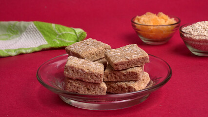 Indian makar sankranti festival food or sweets. Tilgul in a small bowl. Tilgul is made out of sesame seeds, peanuts, and jaggery. Til gud chikki or sesame candy. Copy Space.