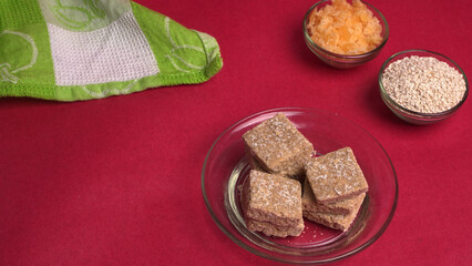 Indian makar sankranti festival food or sweets. Tilgul in a small bowl. Tilgul is made out of sesame seeds, peanuts, and jaggery. Til gud chikki or sesame candy. Copy Space.