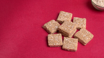Indian makar sankranti festival food or sweets. Tilgul in a small bowl. Tilgul is made out of sesame seeds, peanuts, and jaggery. Til gud chikki or sesame candy. Copy Space.