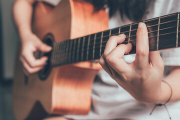 Close up of women hand playing guitar.