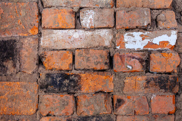 Repair of an old brick wall of a home stove. Different red bricks are laid in the wall after repair. Brick background