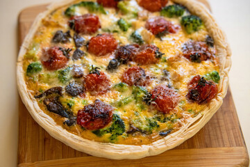 Close up of appetizing baked quiche lauren pie on wooden board