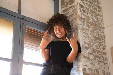 Beautiful woman riding in the window of her studio. Woman makes different gestures looking at camera and having fun. There is a lot of natural light in the studio. Concept expressions and moods.