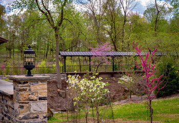 A Lonely Train Station in the Woods With a Stream and Stone Wall by a Covered Bridge on a Sunny Spring Day