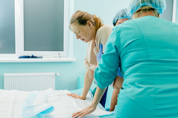 Professional medical staff and doctor help a woman in childbirth in hospital.