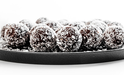 Chocolate balls on a black ceramic plate.