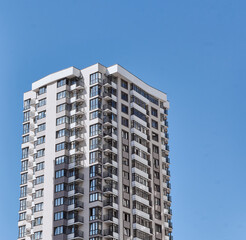 Modern new residential concrete high-rises on a background of the sky. Front view part of multi-storey new built. Modern multi-storey residential area. Residential fund.