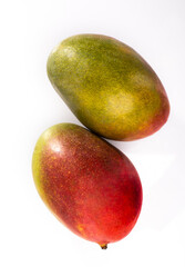 Two whole mango fruits, isolated. Ripe exotic fruits on a white background, top view.
