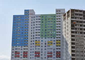 Modern new residential concrete high-rises on a background of the sky and construction nearby. Housing construction. Economic housing stock of construction. 