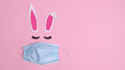 Creative Easter bunny with face mask on pastel pink background. Flat lay minimal copy space