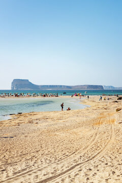Tourists on the famous Balos beach, with Gramvousa island in the background 