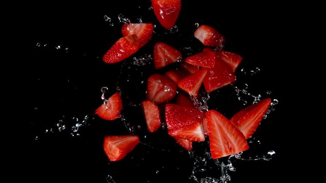 Super slow motion of rotating strawberries with splashing water, top view Filmed on high speed cinema camera, 1000 fps. Top shot.