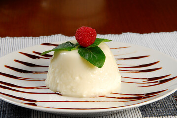 Rice pudding. Rice pudding dessert garnished with raspberry on a plate with lines of liquid chocolate
