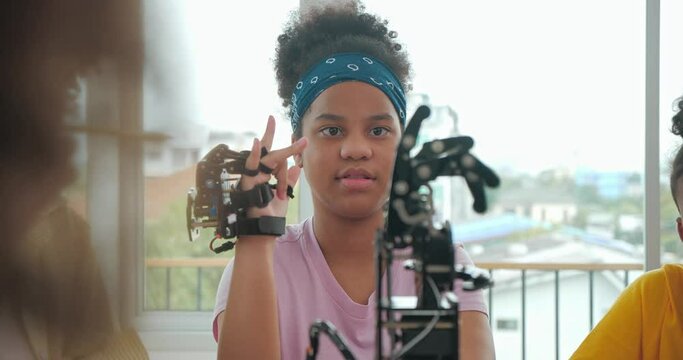 African black kids is playing with robotic arm in a school. Group student is controlled by hand. Technology and Innovation concept.