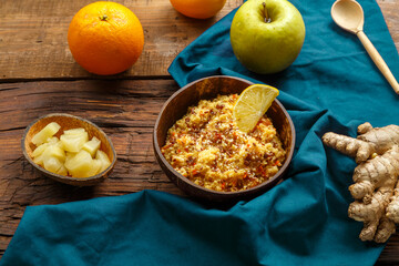 Couscous masfouf with dried fruits and nuts in a plate on a blue napkin on a wooden table next to a...