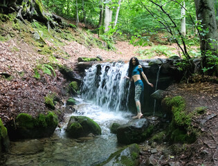 woman near mountain waterfall