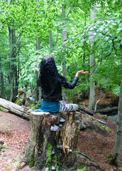 woman sitting on a stump in the lotus position..