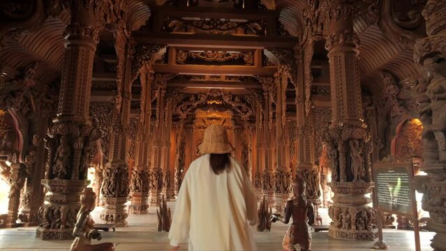 Sanctuary of Truth (Prasat Sut Ja-Tum), Rear view of woman 
tourist at beautiful Thai wooden temple interior in Pattaya Thailand, Amazing Thailand travel concept.
