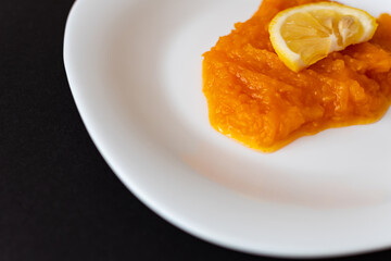 Vegetable puree, pumpkin porridge with lemon on a white plate, healthy food, natural products, vegetarian products