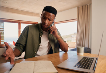 Young adult black male in heated argument while talking on the phone. Sitting in modern apartment...