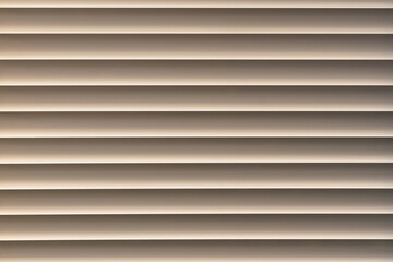 Obraz premium Closed window blinds illuminated by the sun, background texture