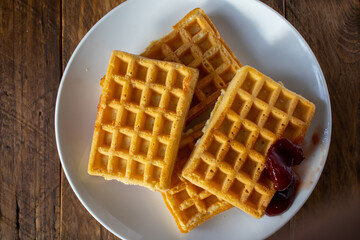 fresh baked waffle in a pattern on wooden background, top view
