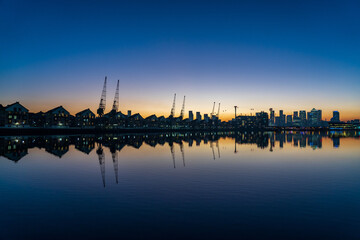 Blue hour over the London skyline with blue sky reflecting in the water.